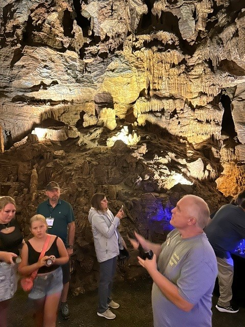A group of people walking around inside of a cave