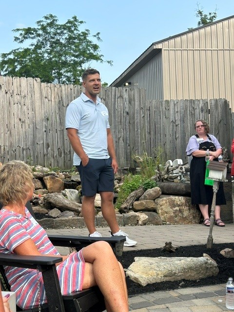 gentleman speaking to event attendees on an outdoor patio