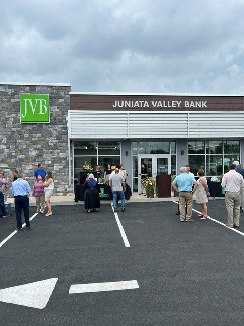 Several people gathering in the parking lot outside the entrance to a bank