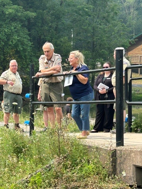 Senator Judy Ward speaking with a scout master on a bridge as they look at the repairs that were recently done